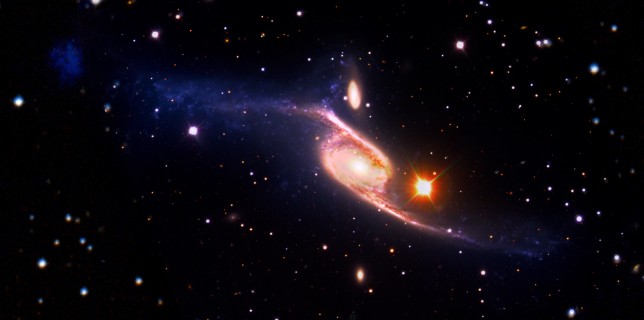 This composite of the giant barred spiral galaxy NGC 6872 combines visible light images from the European Southern Observatory's Very Large Telescope with far-ultraviolet (1,528 angstroms) data from NASA's GALEX and 3.6-micron infrared data acquired by NASA's Spitzer Space Telescope (NASA's Goddard Space Flight Center/ESO/JPL-Caltech/DSS)